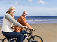 senior-couple-bicycle-beach
