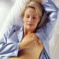 woman-bed-breast-self-exam