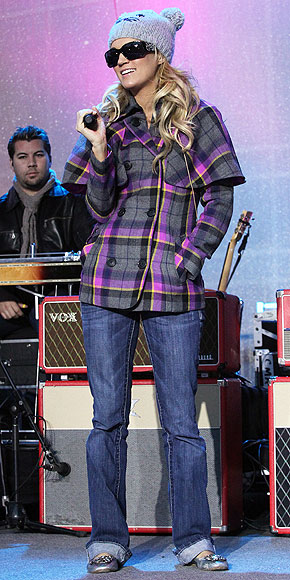 The country singer stays cozy on stage in a cute knit hat, plaid coat, cuffed jeans and silver flats. Which piece is under $100? | Carrie Underwood