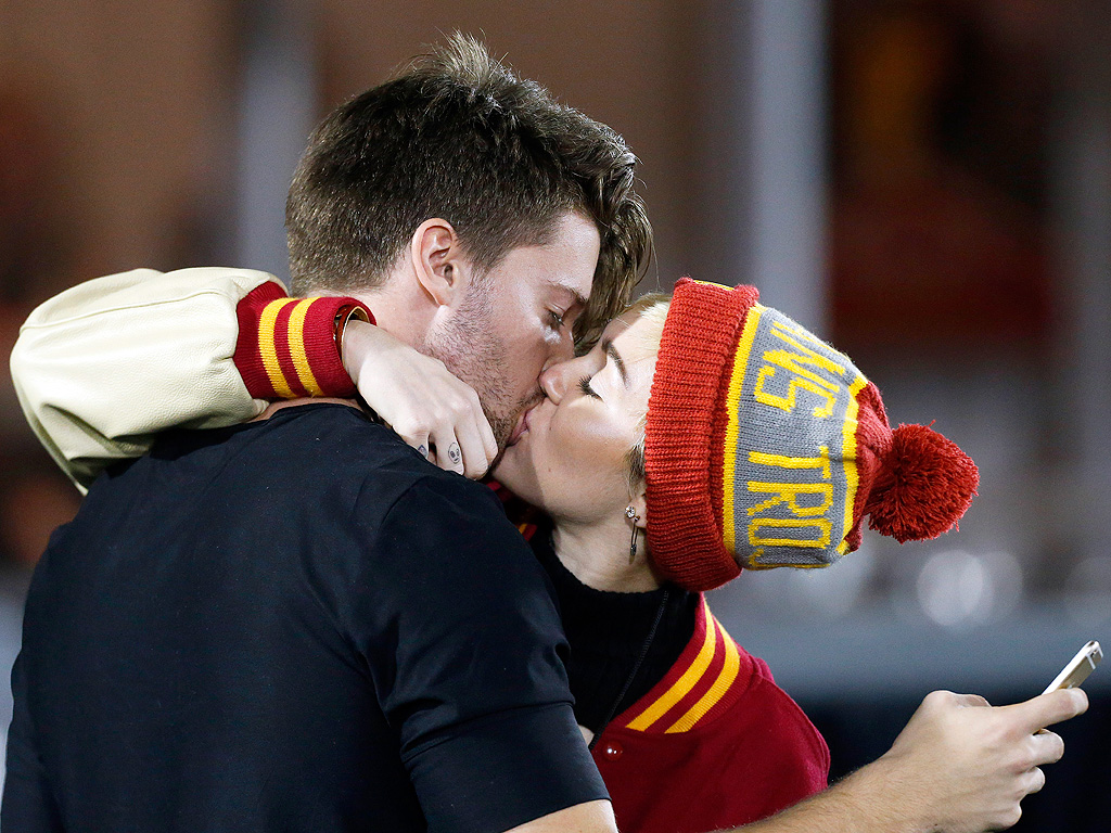 Miley Cyrus & Patrick Schwarzenegger Kiss at USC Game: Photo