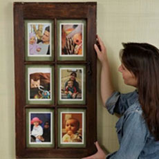 woman hangs picture frame on wall