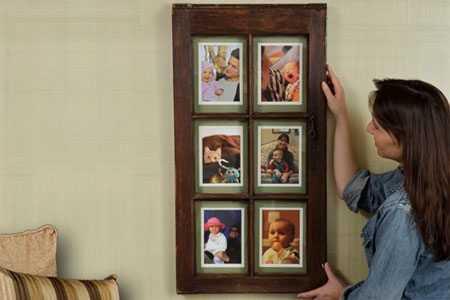 woman hangs picture frame on wall