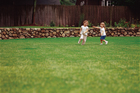 2 little girls playing on a lawn