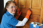 woman with gloves working on door using denatured alcohol