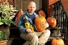 This Old House Editor, Scott Omelianuk with a reciprocating saw and some pumpkins sitting on his front stoop