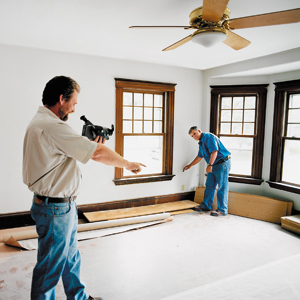 one man holding camera and other marking lines for insulation