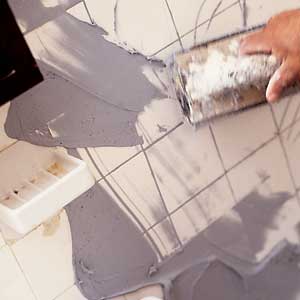 spreading grout on tub tiles