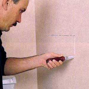 cutting a hole behind the old tub faucet