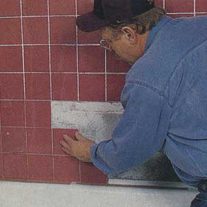 pressing shower tiles into the mastic 