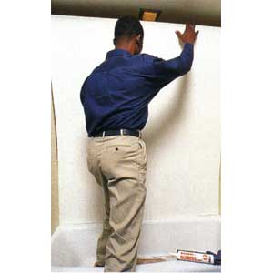 installing the tub surround panel against the wall