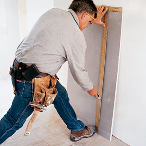 Tom Silva cutting drywall to size 