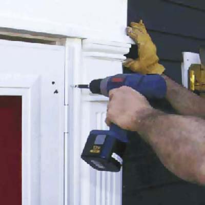 Set the door into the opening and drive screws through the mounting flange and into the existing wood brick mold