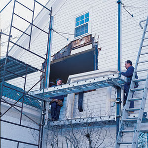 Tom and Dick Silva pump-jacking the new bay window up to the opening