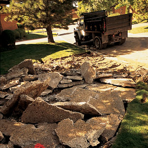 The 18-year-old concrete drive, riddled with cracks, is broken up with a hydraulic jackhammer and hauled away. Concrete and asphalt can be pulverized and reused as roadbed, the gravelly base for pavement.