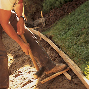 Forms made from 1x6 boards are staked into place to shape and hold the concrete. These will be removed after it sets up. 