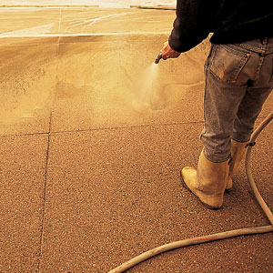Two to 12 hours after the retarder is applied, the plastic is peeled back and the driveway is hosed down with water. Fine cement particles and sand are washed from the surface, exposing the aggregate beneath. Then a muriatic acid solution is applied to clean the stone. The next day, an acrylic sealer is sprayed on to protect the surface from staining and weathering. The sealer also makes the surface appear damp, bringing out the colors of the aggregate. For best results, the sealer, which is available at home centers, should be reapplied every two to five years, depending on weather conditions. In about ten days, the driveway is firm enough for traffic. 
