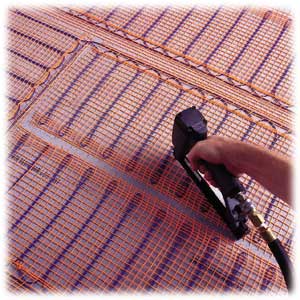 Secure the mat. Plywood or cement backerboard will work as a substrate for the heating cable. Staple into the plastic mat, not into the cable.