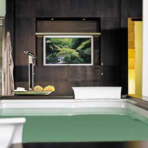 Flat screen TV hanging on the wall over a bathtub