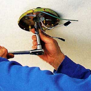 securing the fan's ceiling plate with lag screws 