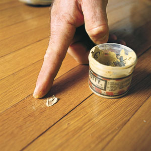 applying putty to the wood floor