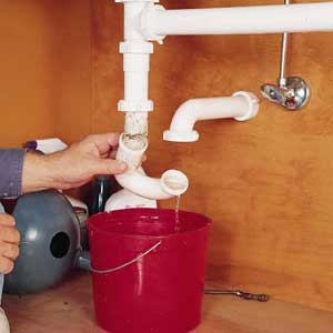Unscrew the sink trap and drain the water into a bucket. Then remove the horizontal trap arm from the back wall.