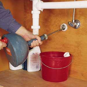Photo 2: FEED THE flexible cable directly into the drainpipe. Turn the crank clockwise to advance the cable and cut through the clog. 