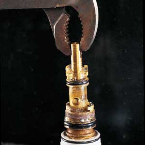 pliers pulling the cartridge from the faucet