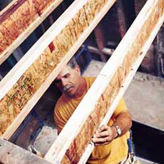 Tom Silva stiffening i-joists before installing a floor