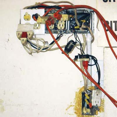 overextended and poorly maintained outlet is a mess of wires and cords
