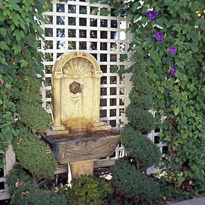 Trellis with hanging plants and a small fountain
