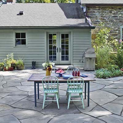 broken-bluestone patio with outdoor table and chairs