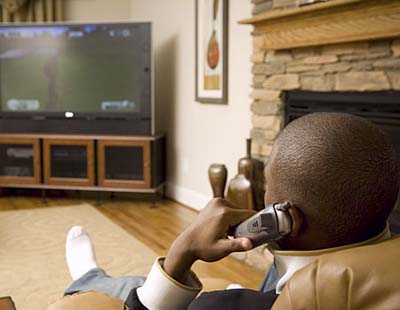 NBA star Chris Paul in front of widescreen TV