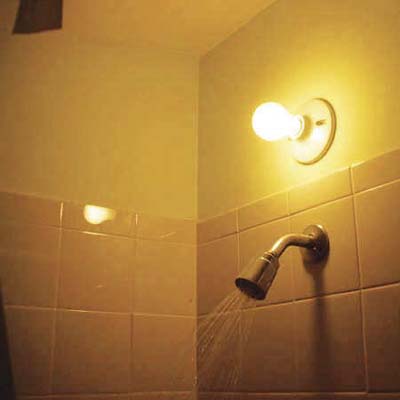 working, exposed lightbulb installed inches above a working shower head