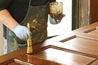 brushing a final coat of satin spar varnish onto a wood door