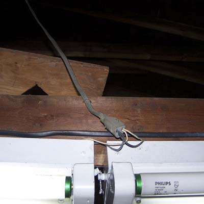 overhead lights loosely connected to an extension cord by inserting bare wires in