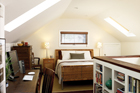 attic bedroom with built-in shelves and skylights
