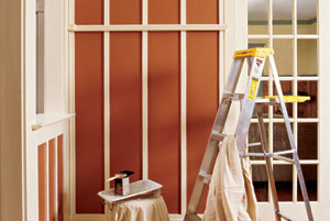 ladder tarps and paint can in interior room in the late stages of being painted