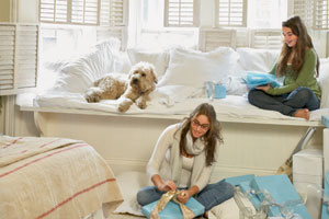 two young women and their dog enjoying a window seat