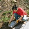Man placing concrete block in soil 