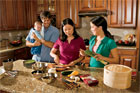family standing over stone countertop in kitchen