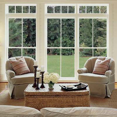 glass doors and windows looking out over a green lawn from a living room