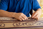 focus on hands assembling a handmade border for a wood floor