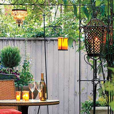 candles and lanterns at different heights in outdoor dining space