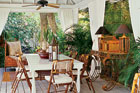 a covered patio with British Colonial style furnishings