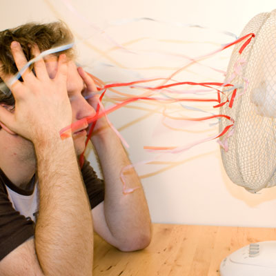 man cooling down in front of oscillating fan