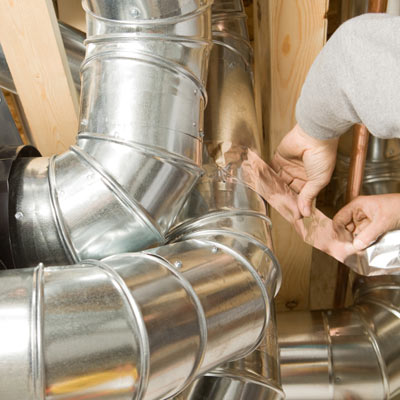 man sealing air duct with tape