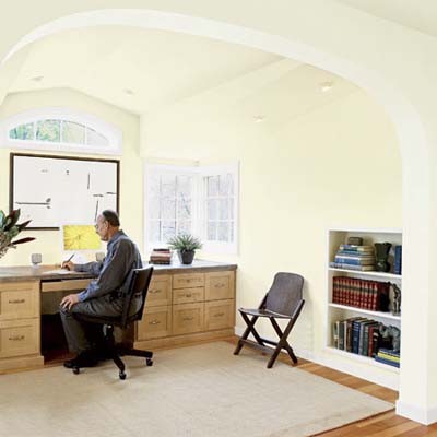 a large open archway separating the office and library in this attic remodel