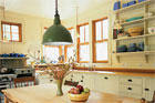 large green pendant light hanging over a rustic kitchen table