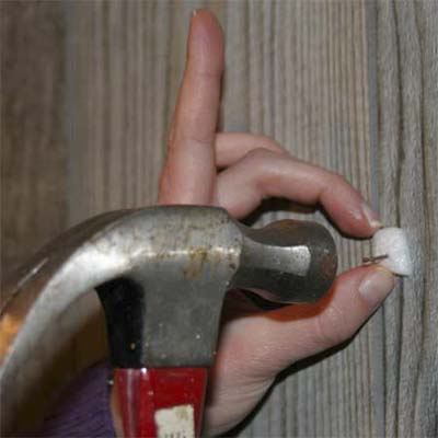 use a packing peanut to hold a small nail in place against the surface you're driving it into