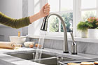 woman touching delta's pilar touch two point zero hands free faucet